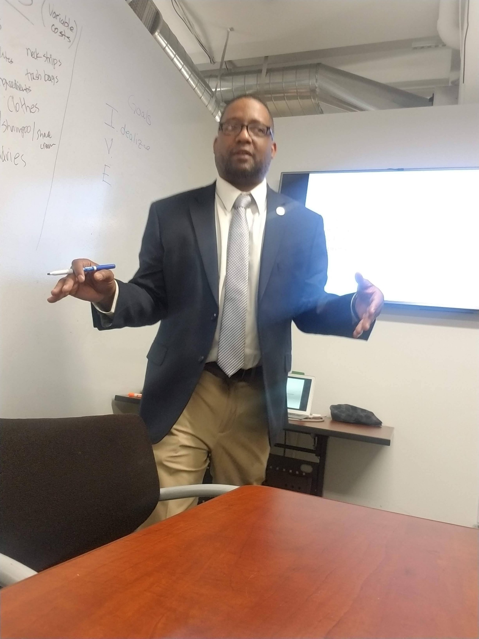 Jonathan McMillan discussing a plan beside a whiteboard