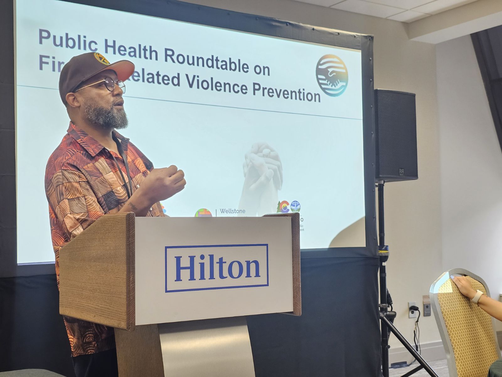 Jonathan McMillan speaking from a podium at a public health roundtable